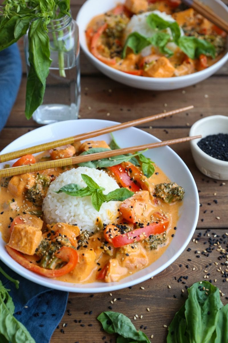 Bowls of red curry salmon with sprinkles of sesame seeds.
