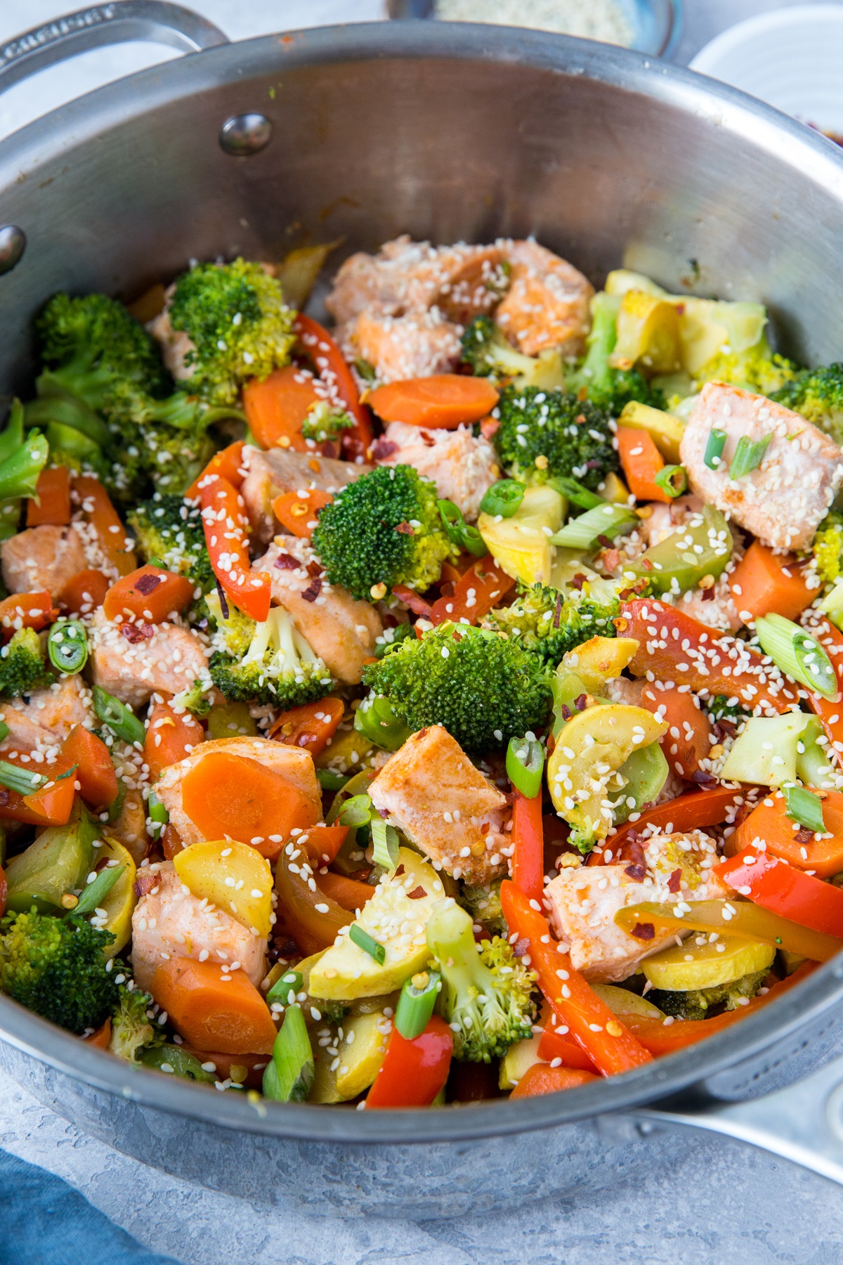 Stainless steel skillet with salmon stir fry in it, ready to serve.