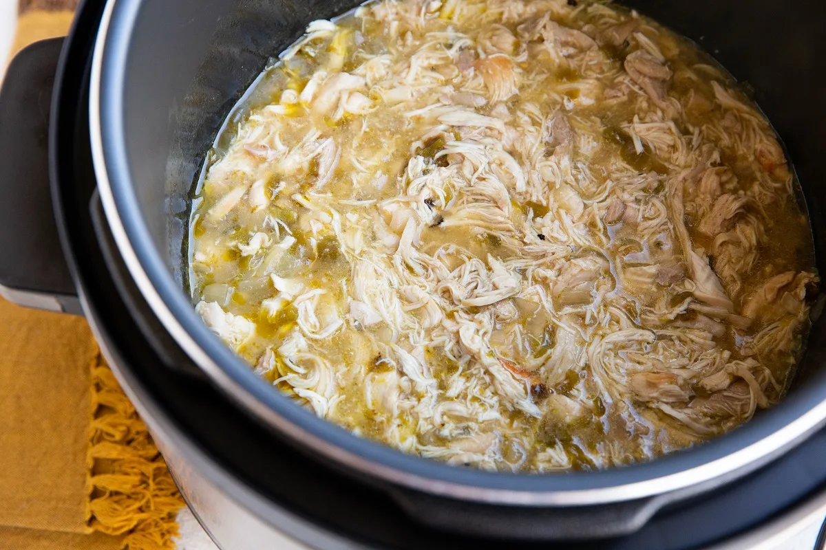 Shredded chicken in an Instant pot with salsa verde.