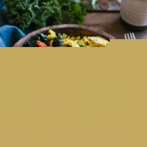 Turmeric quinoa with sauteed onions, peppers, and a sunny side up egg with half an avocado to the side.