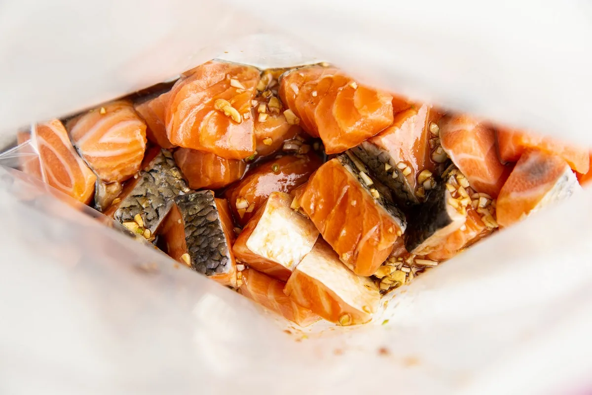 Chunks of salmon and a marinade in a zip lock bag, ready to marinate.