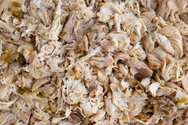 Shredded chicken on a cutting board.