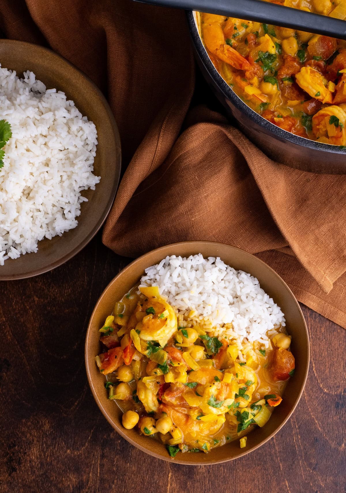 Coconut Shrimp and Chickpea Curry in a bowl with white rice. A bowl of white rice and more curry to the side