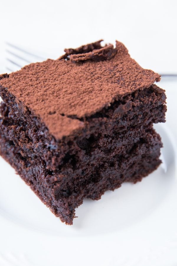Thick slice of sourdough chocolate cake on a white plate, ready to serve.