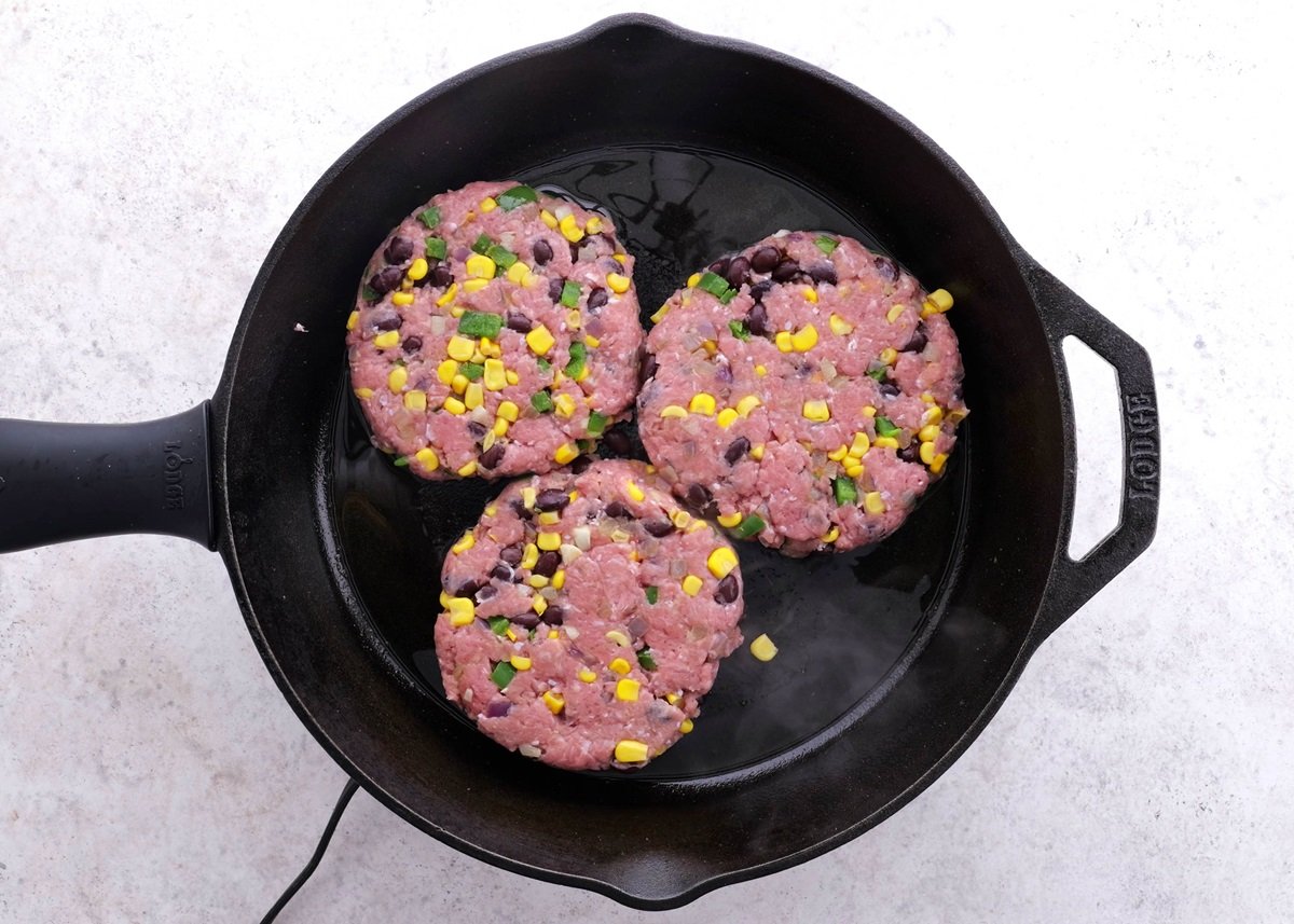 Southwest Turkey Burgers cooking in a large cast iron skillet