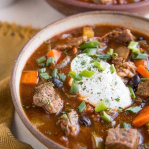 Two large bowls full of steak chili with beans and fresh vegetables. Ready to serve.