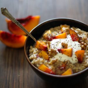 Bowl full of oatmeal with chopped peaches and chia seeds.