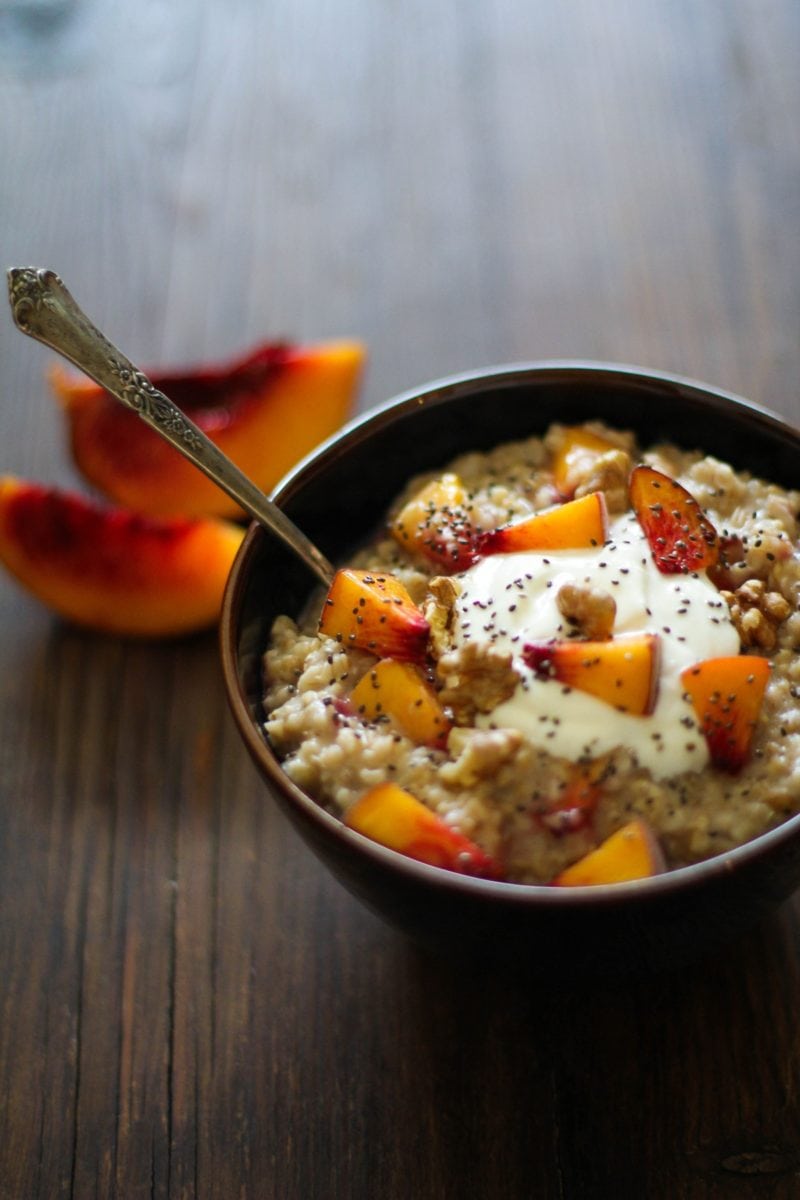 Bowl full of oatmeal with chopped peaches and chia seeds.