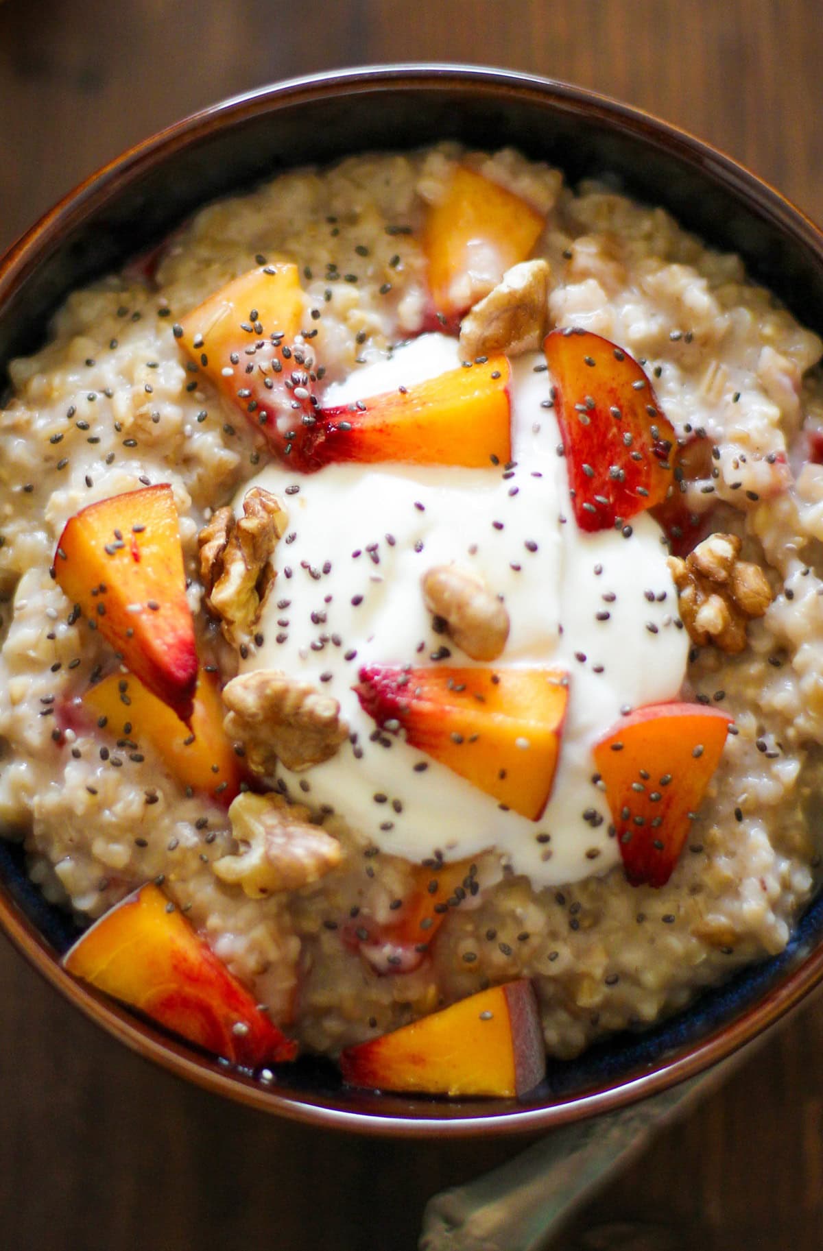 Bowl full of oats with chopped fruit on top.