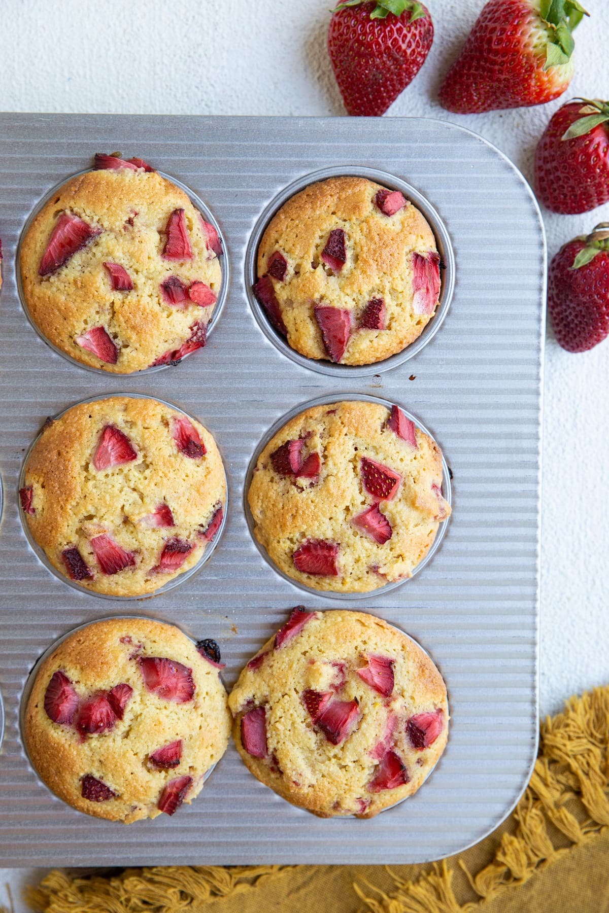 Muffin tray with strawberry muffins, fresh out of the oven.