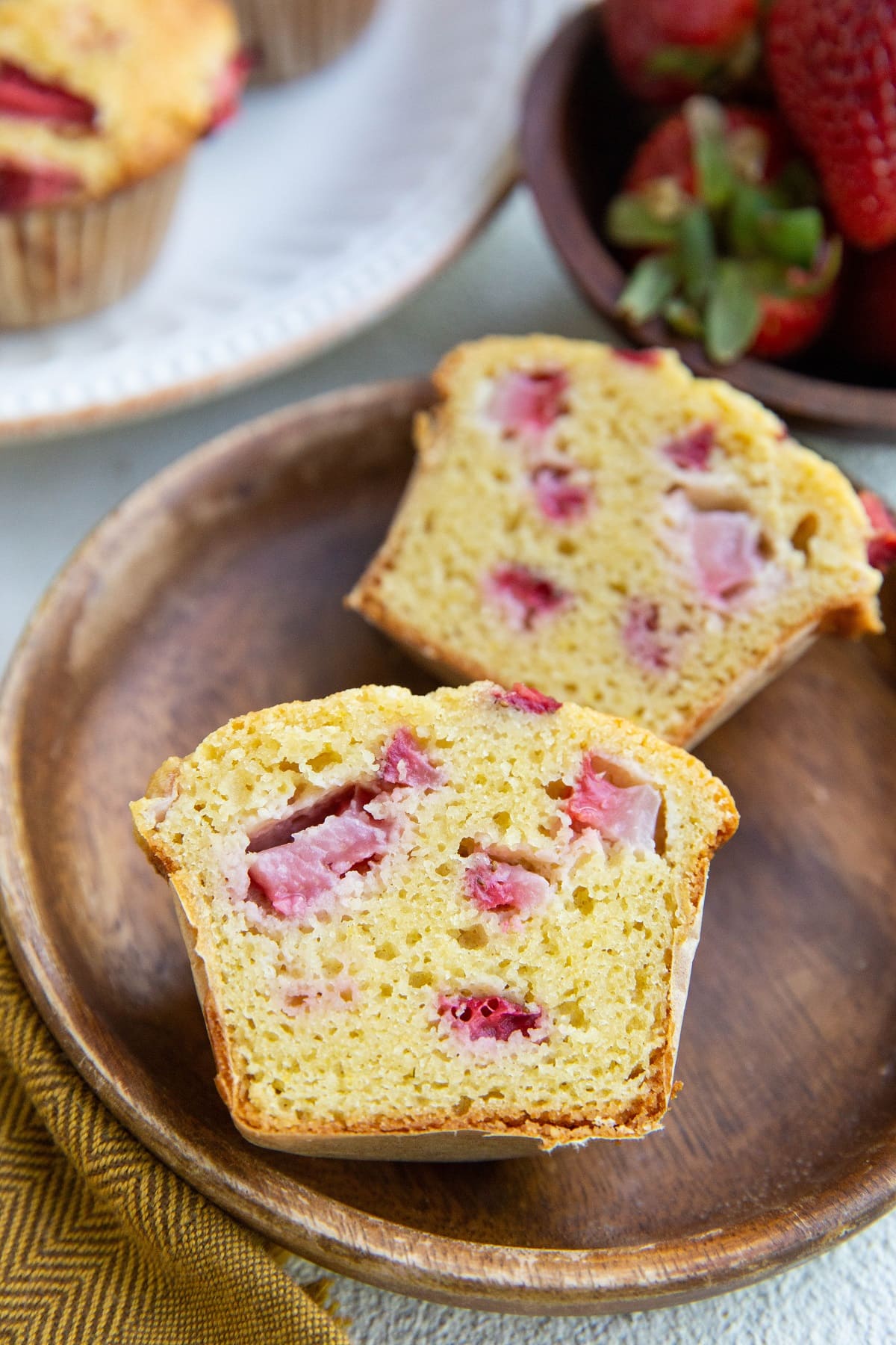 One strawberry muffin sliced in half on a small plate so you can see the moist inside.