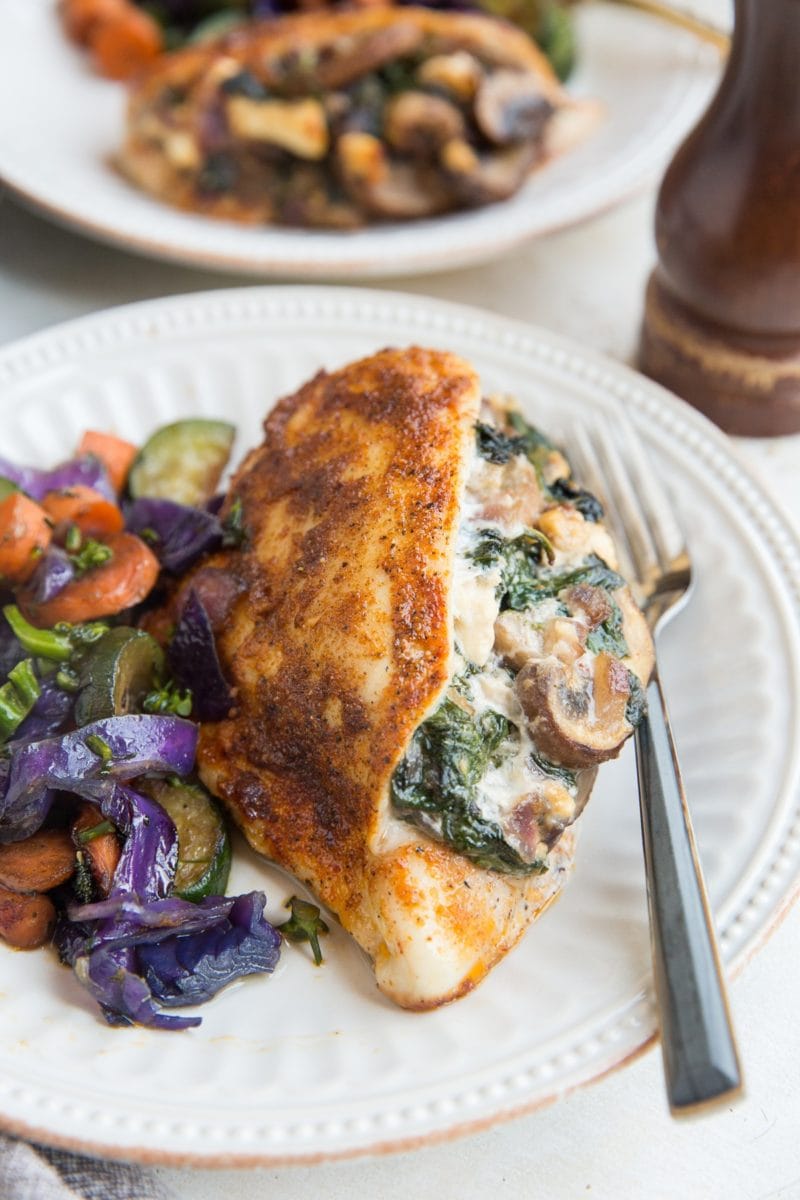 Mushroom and Spinach Stuffed Chicken Breast with roasted vegetables for a healthy weeknight dinner.