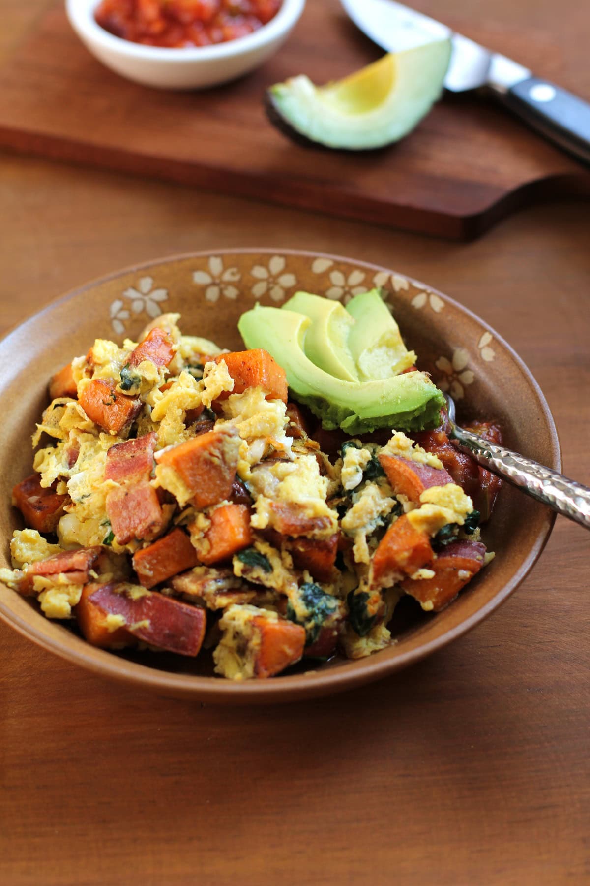 Bowl full of sweet potato, bacon and spinach scramble.
