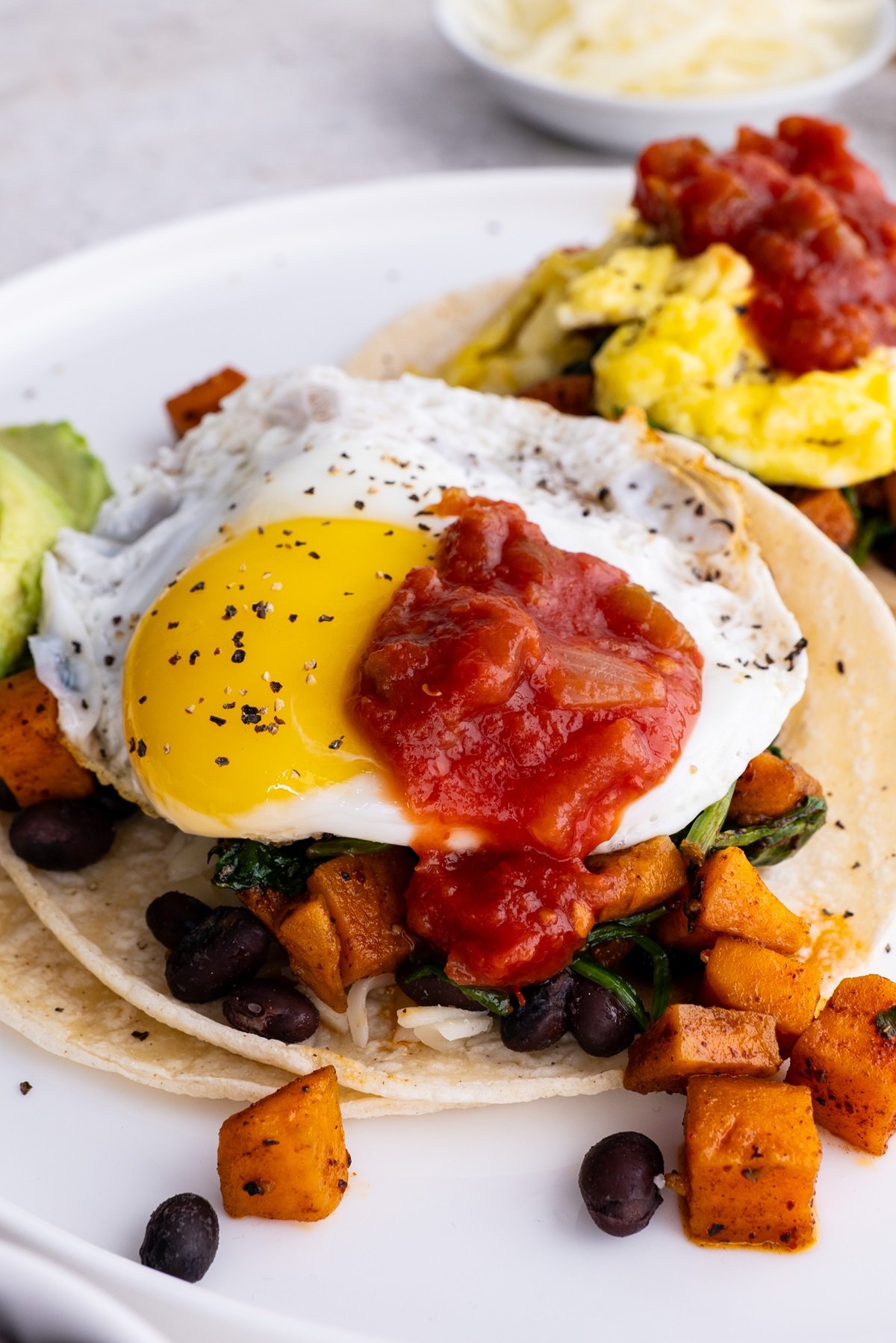 White plate with two breakfast tacos, ready to eat for a healthy breakfast.