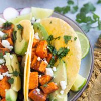 Vegetarian tacos with roasted vegetables and beans on a plate, ready to eat.