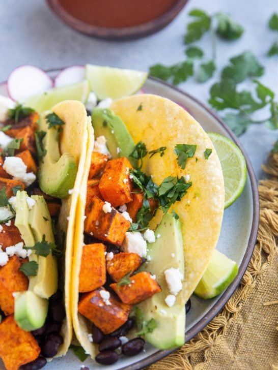 Vegetarian tacos with roasted vegetables and beans on a plate, ready to eat.