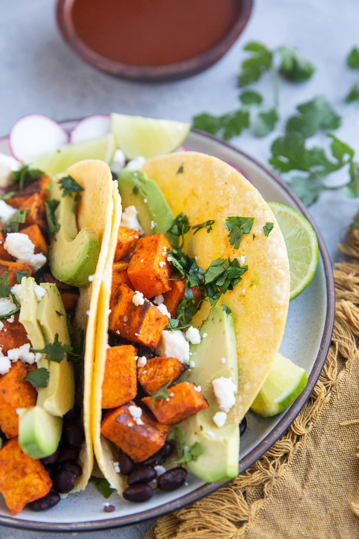 Vegetarian tacos with roasted vegetables and beans on a plate, ready to eat.