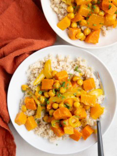 Butternut Squash and Yam Curry in a white bowl with a wood inlay fork and a red napkin to the side.