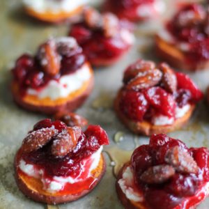 Sweet Potato Rounds with Goat Cheese, Roasted Cranberries on a baking sheet, drizzled with honey fresh out of the oven.