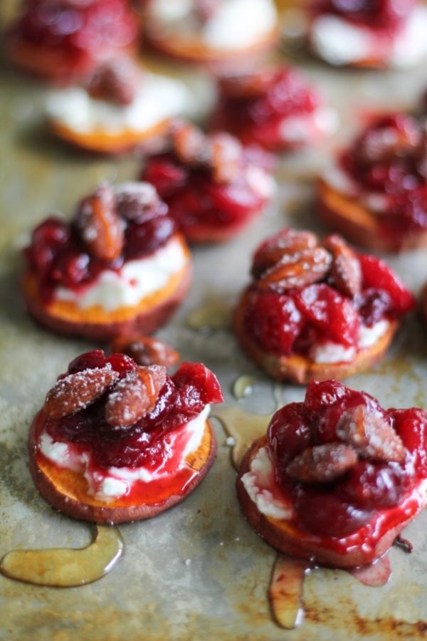 Sweet Potato Rounds with Goat Cheese, Roasted Cranberries on a baking sheet, drizzled with honey fresh out of the oven.