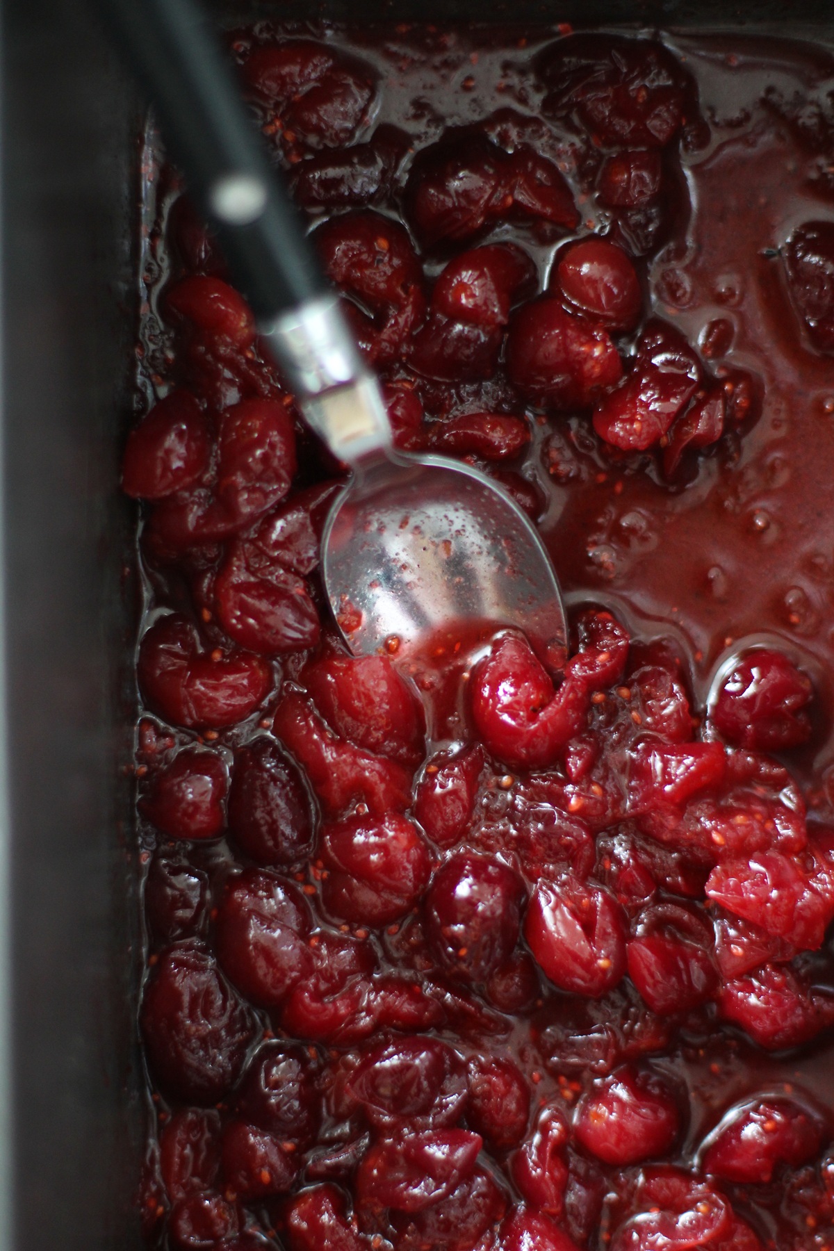 Roasted cranberries in a baking dish, all gooey and ready to go, fresh out of the oven.