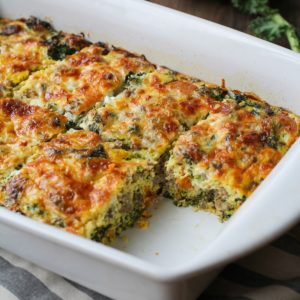 Sweet potato and sausage egg casserole in a baking dish with a piece missing, fresh out of the oven.