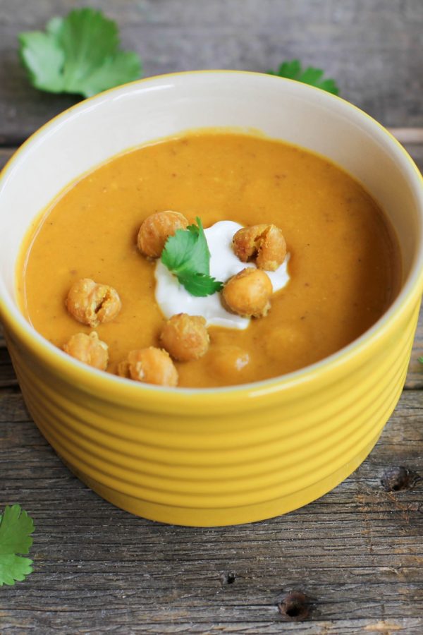 Big bowl of sweet potato soup with roasted chickpeas, yogurt, and parsley on top.