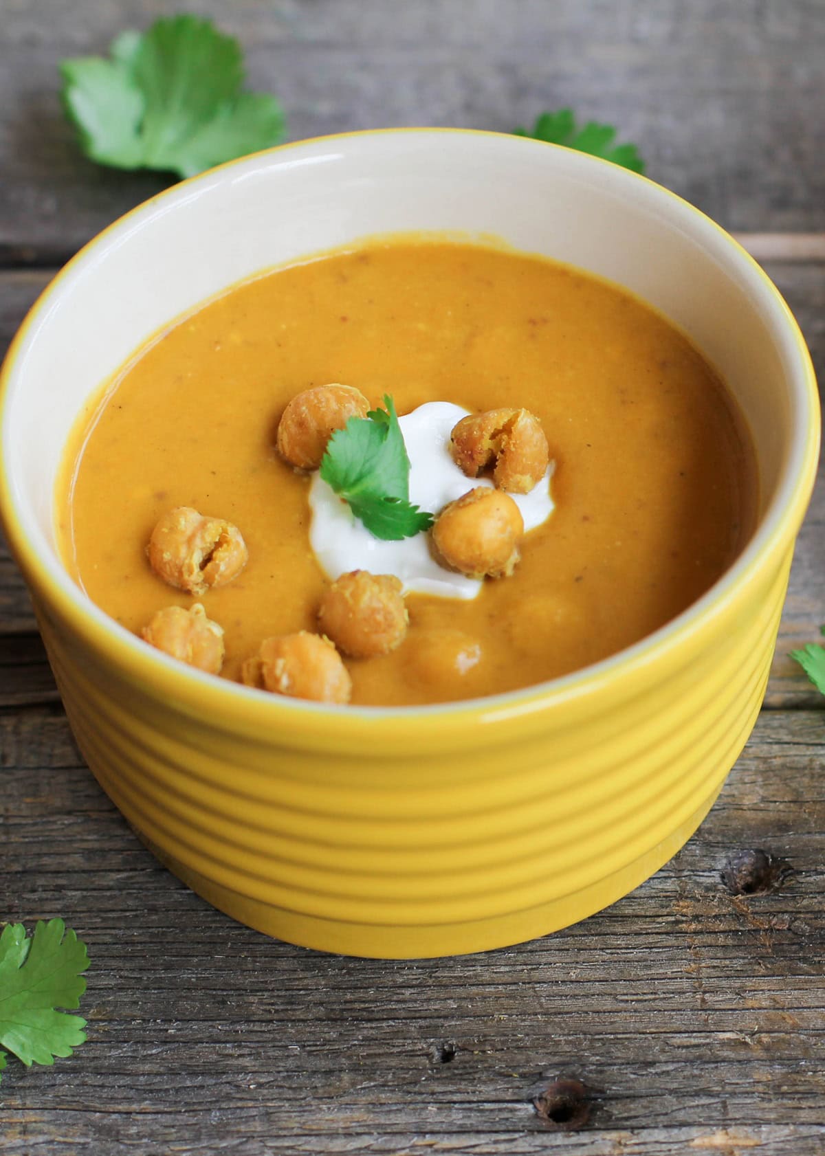 Big bowl of sweet potato soup with quinoa and parsley on top.