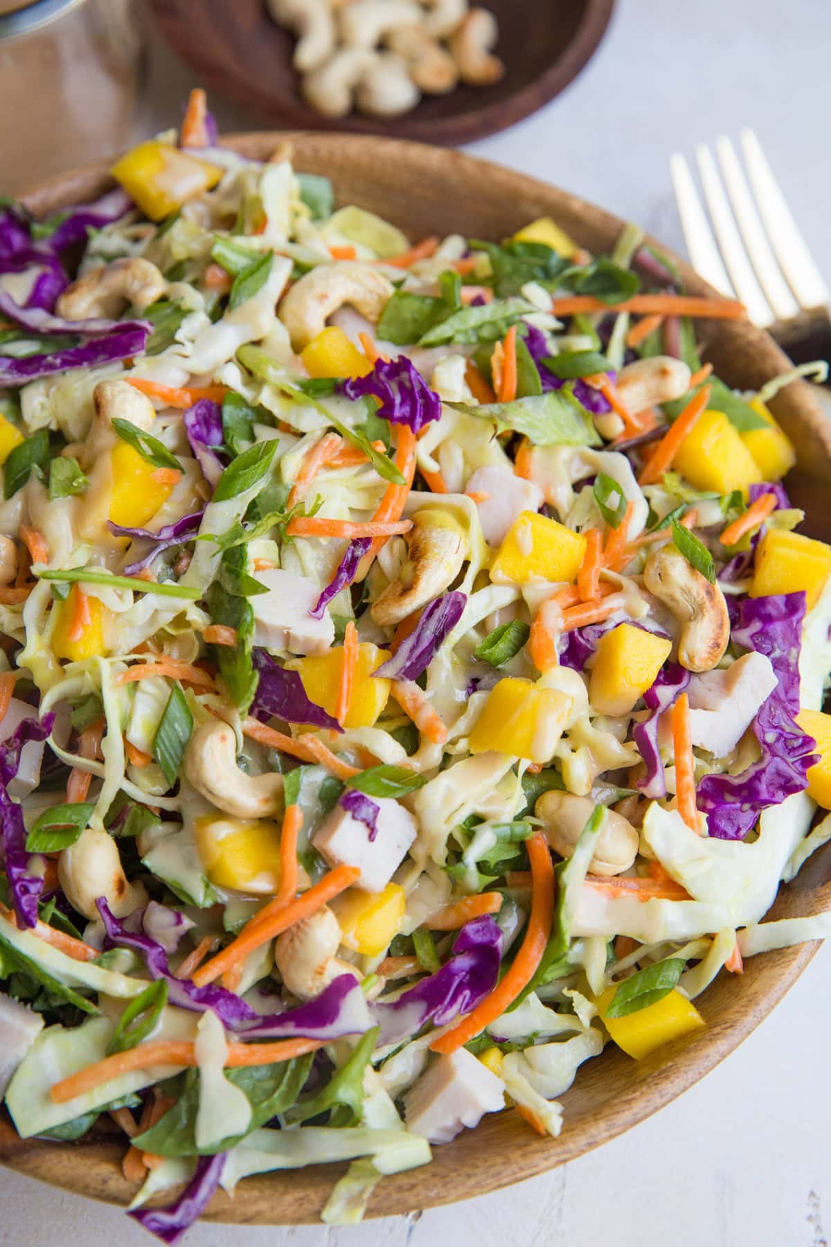 Big wood bowl of Thai cabbage chicken salad with peanut dressing.