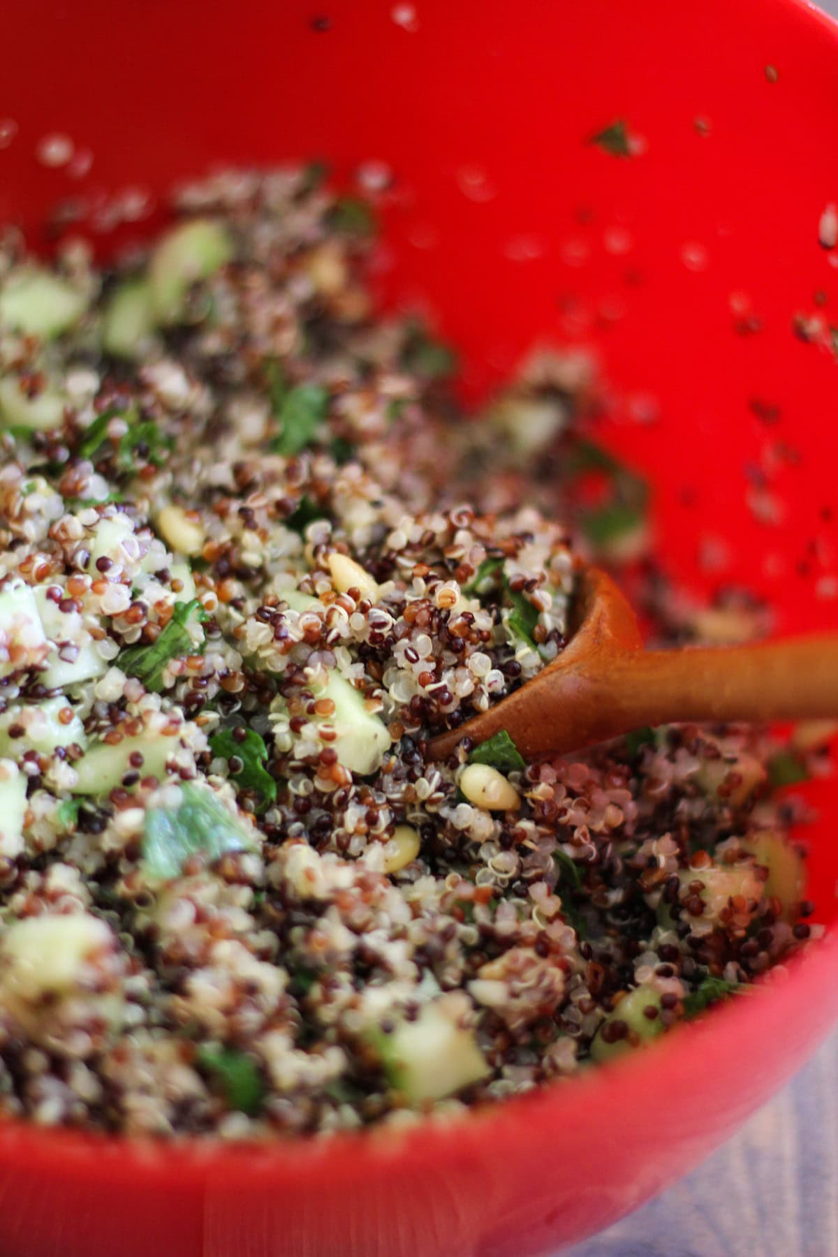 large mixing bowl full of prepared quinoa salad, ready to eat.