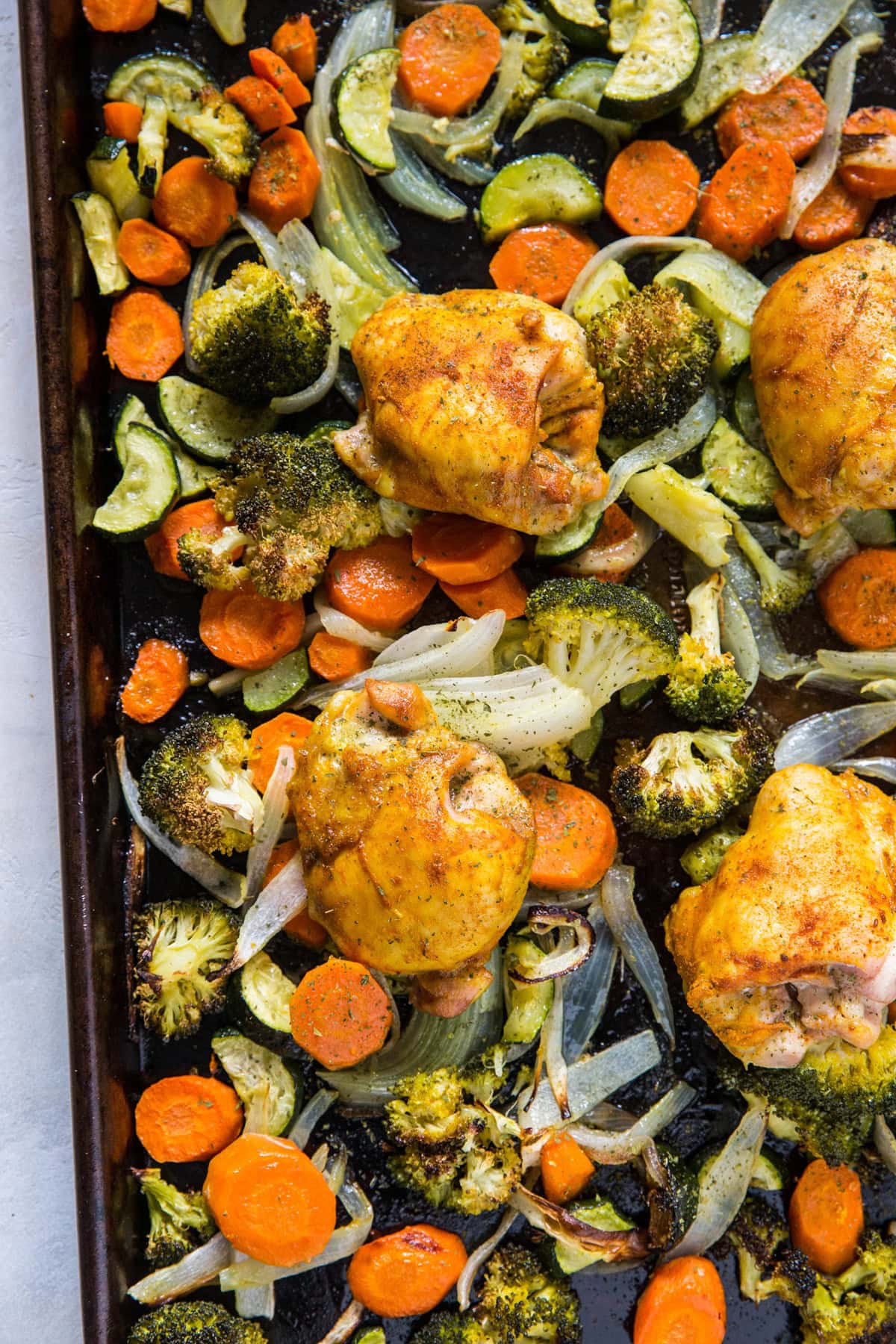 Sheet pan with turmeric chicken and roasted vegetables. Ready to serve.