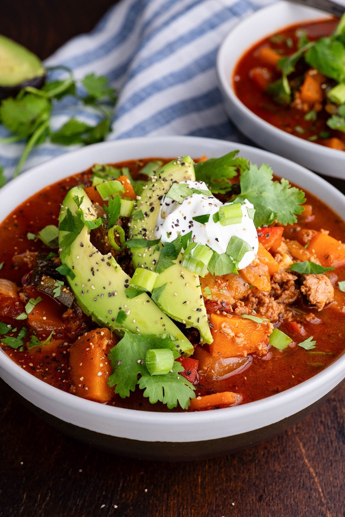 Two bowls of paleo turkey chili with avocado on top. Ready to eat