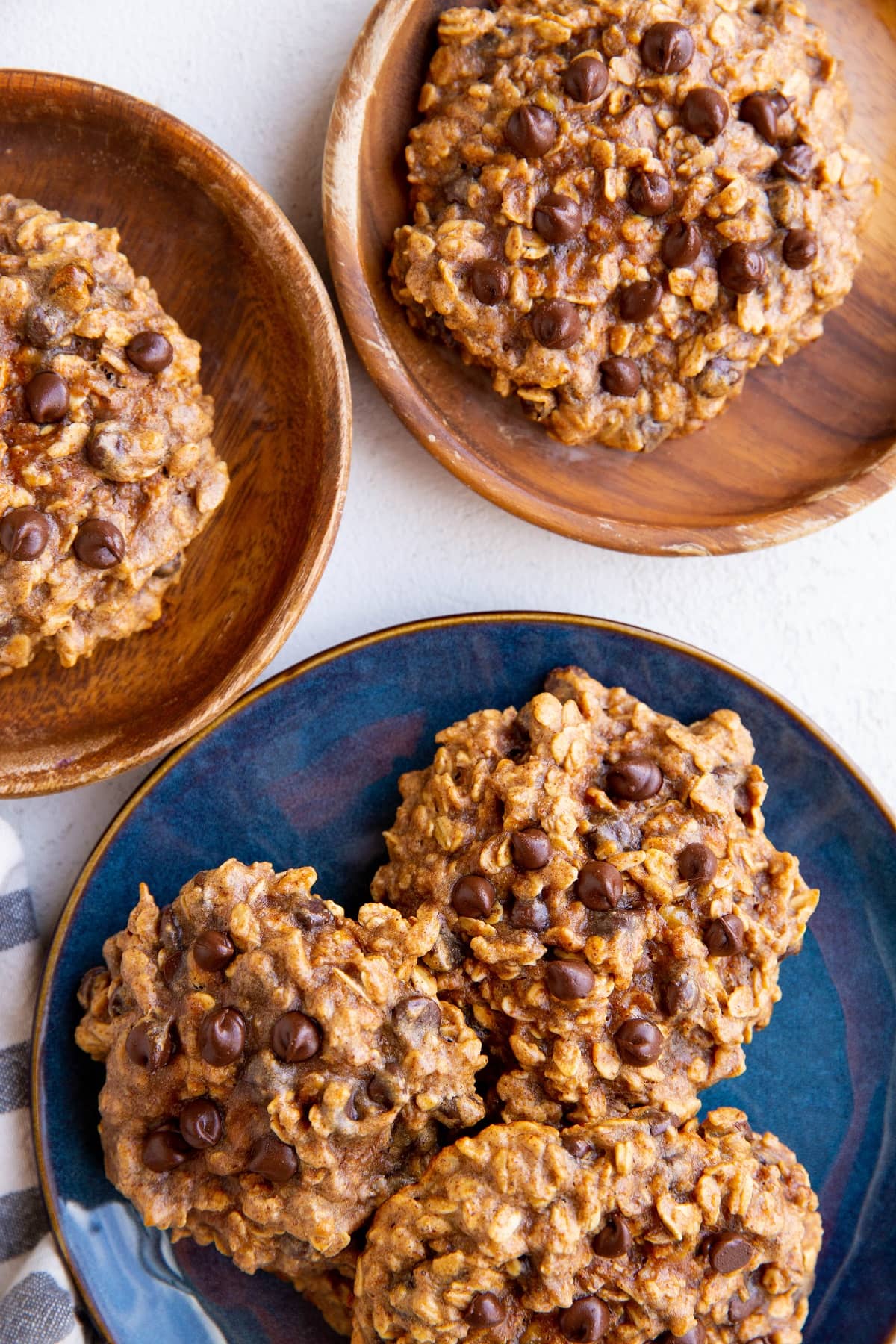 Two wooden plates and one blue plate with cookies, ready to serve.