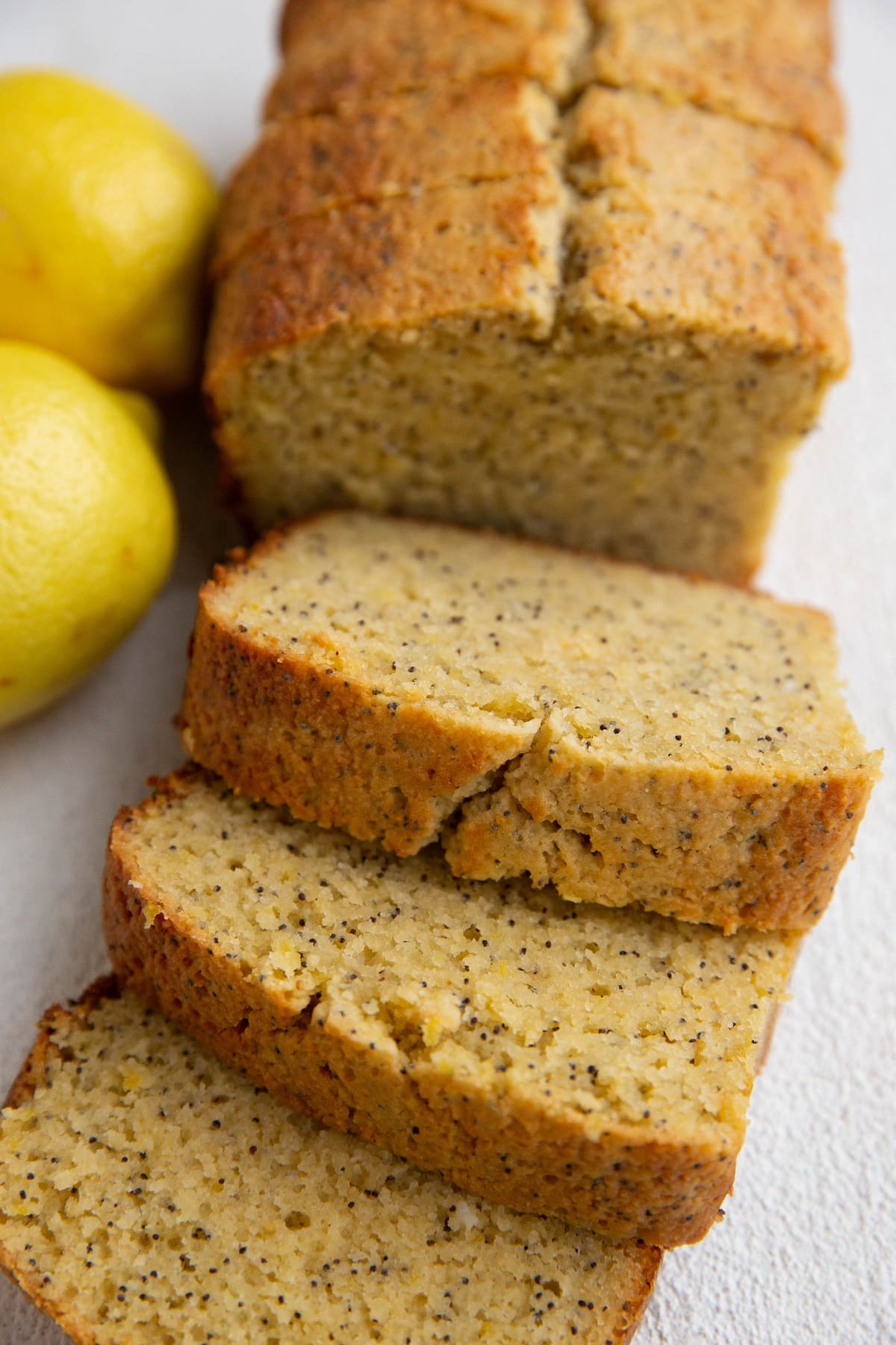 Loaf of lemon poppy seed bread cut into thick slices.