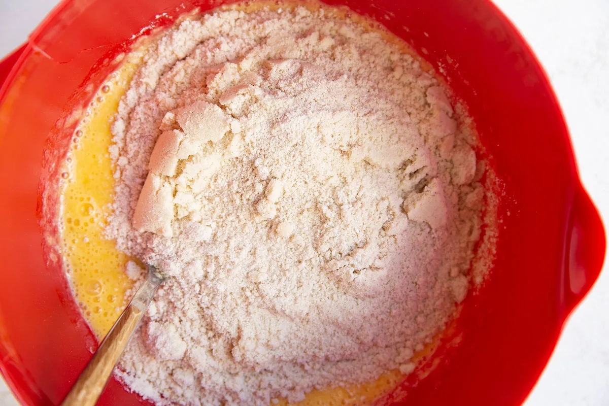 Dry ingredients on top of wet ingredients in a mixing bowl, ready to be mixed together.