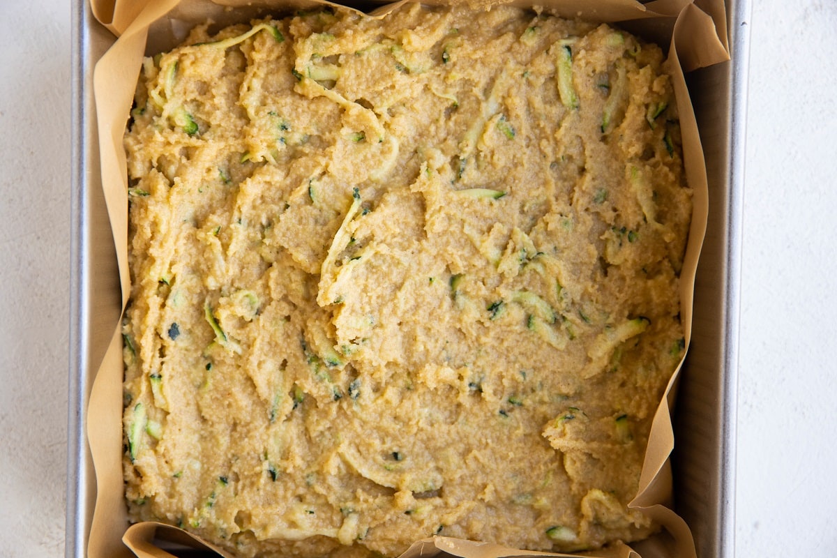 Zucchini cake batter in a square cake pan.