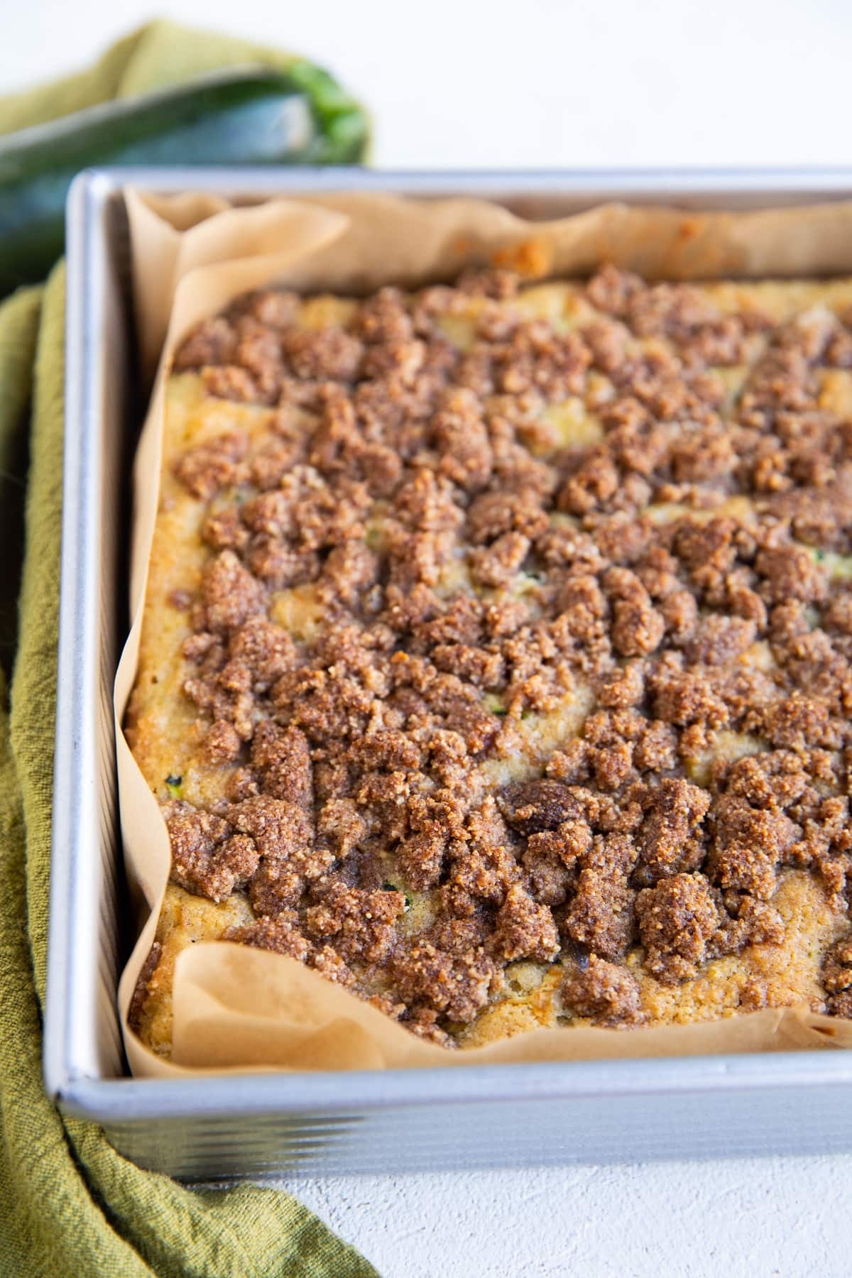 Zucchini crumb cake in a cake pan, ready to eat.