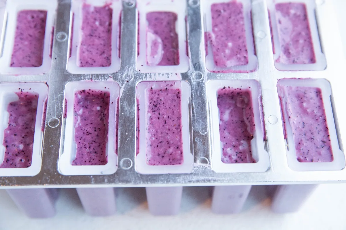 Popsicle mold filled with blueberry popsicle mixture.