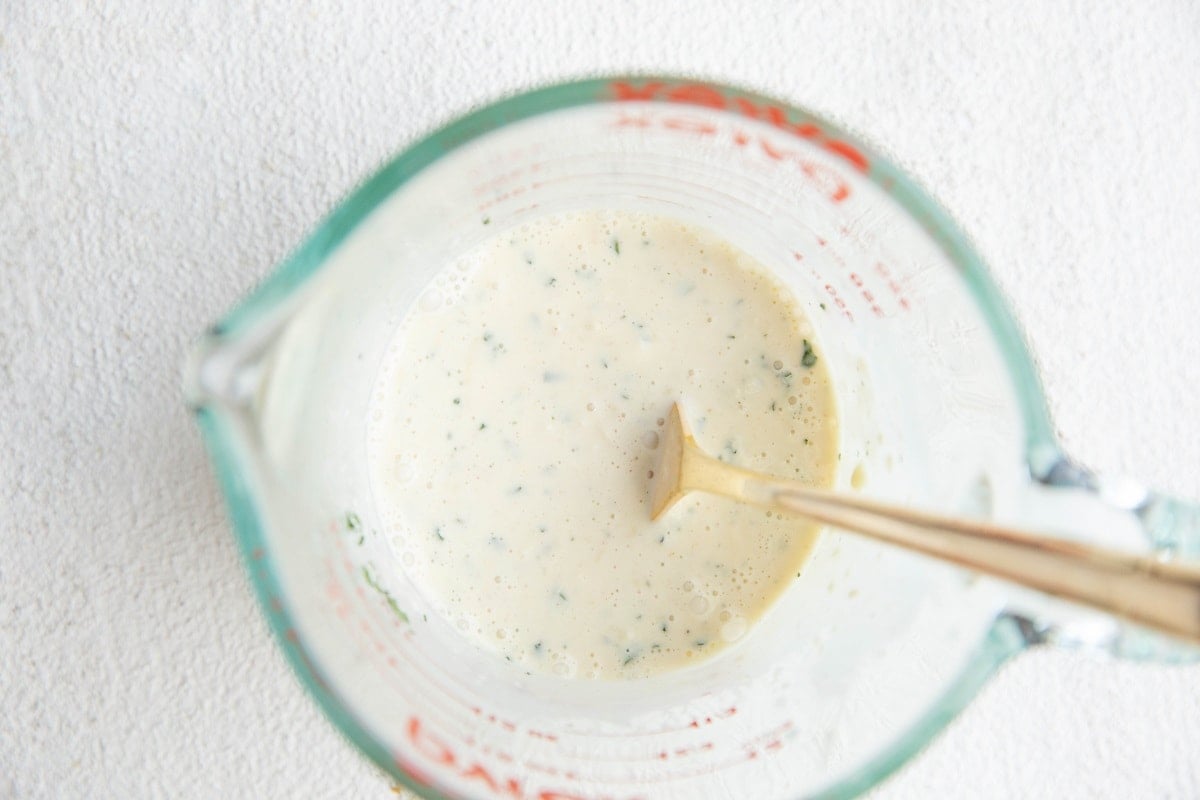 Measuring cup full of coleslaw dressing.