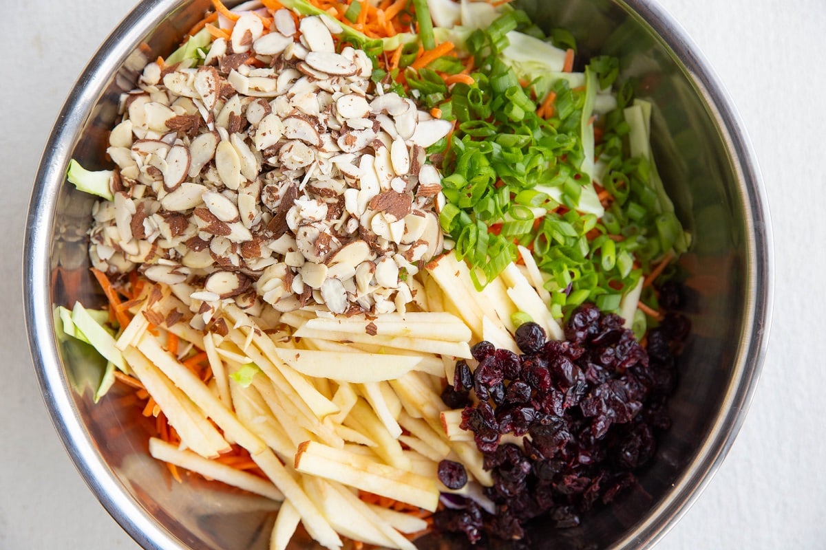 Bowl full of carrot slaw ingredients.