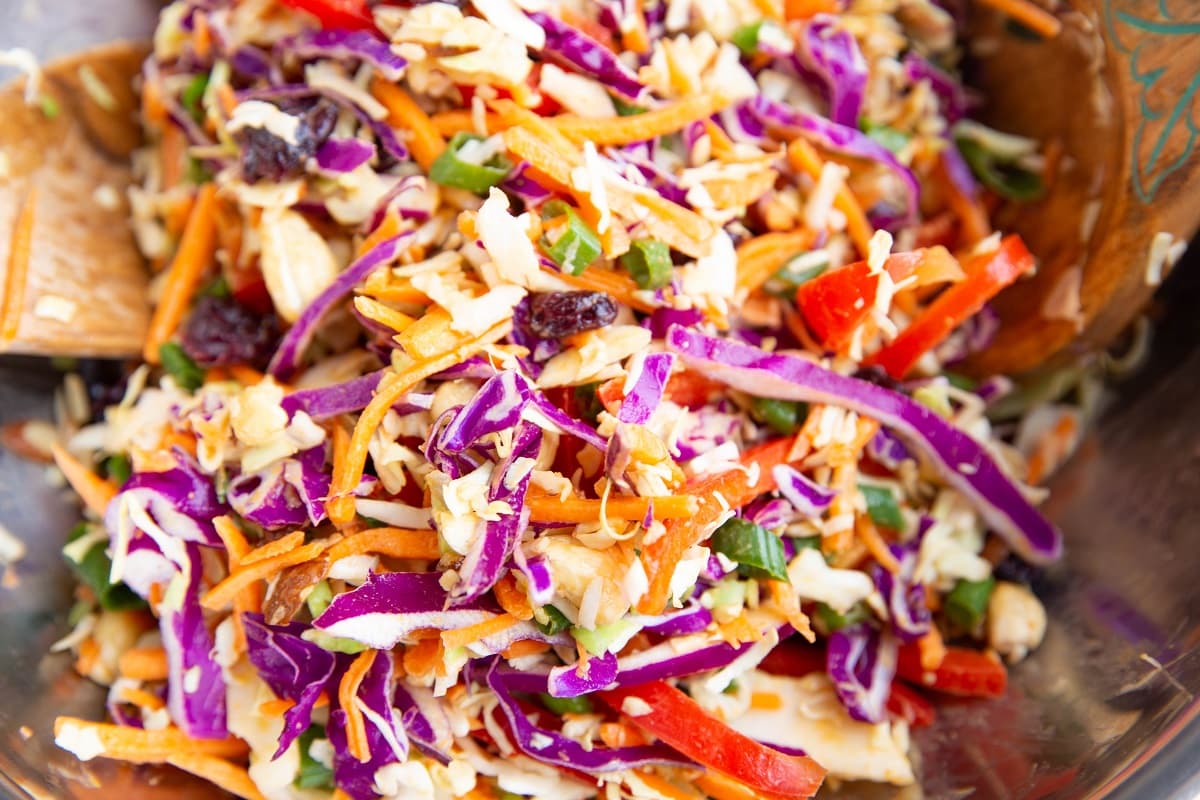 Salad ingredients tossed together in a mixing bowl.