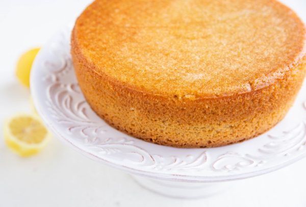 Finished lemon cake sitting on a cake stand.