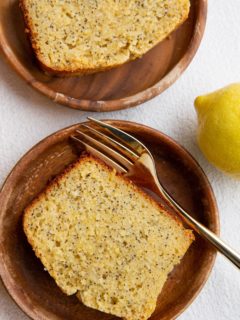 Top down image of two wooden plates with slices of lemon poppy seed bread.