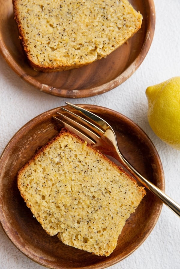 Top down image of two wooden plates with slices of lemon poppy seed bread.