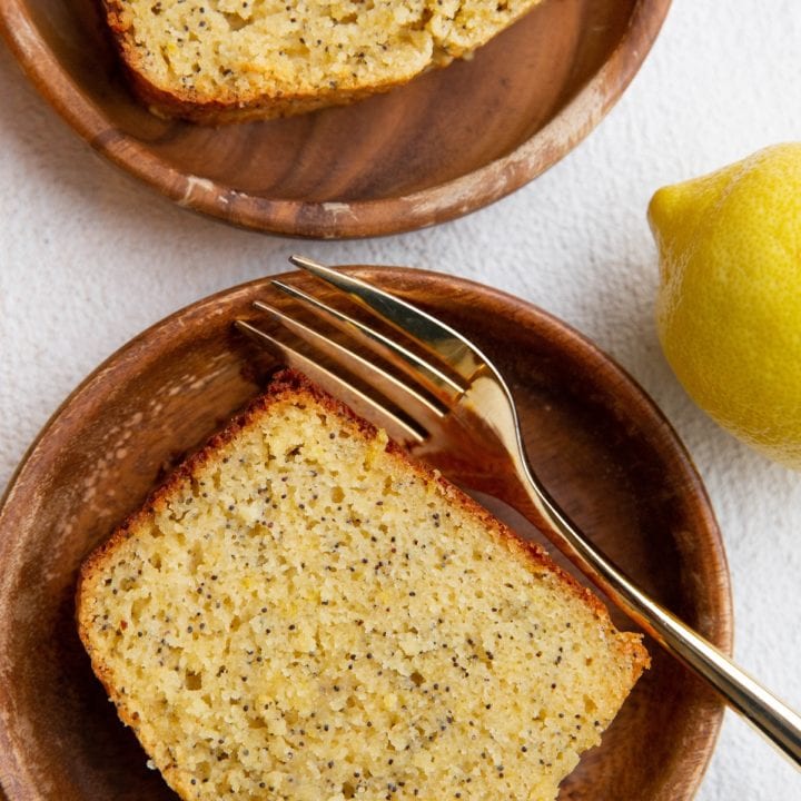 Top down image of two wooden plates with slices of lemon poppy seed bread.