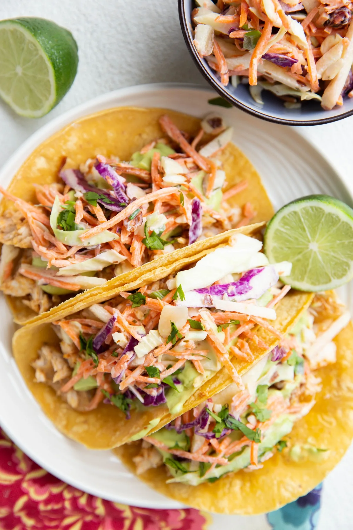 Amazing fish tacos on a plate with fresh limes to the side.