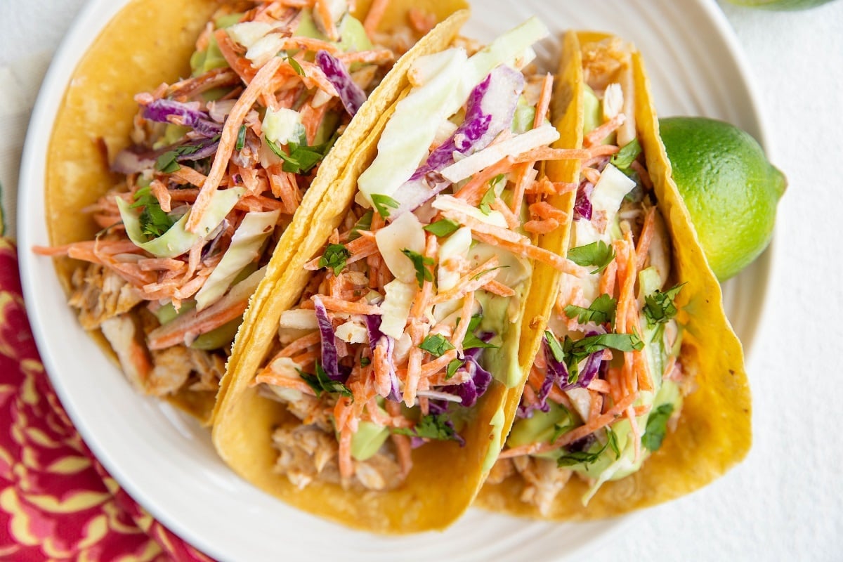 The best fish tacos topped with slaw, avocado sauce and cilantro.