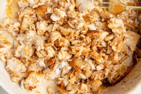 Baked mahi mahi chopped up in a baking dish, ready to be turned into tacos.