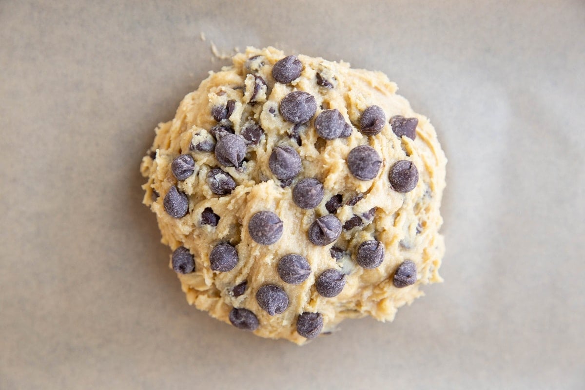 Gluten-Free chocolate chip cookie dough on a parchment lined baking sheet, ready to go into the oven.