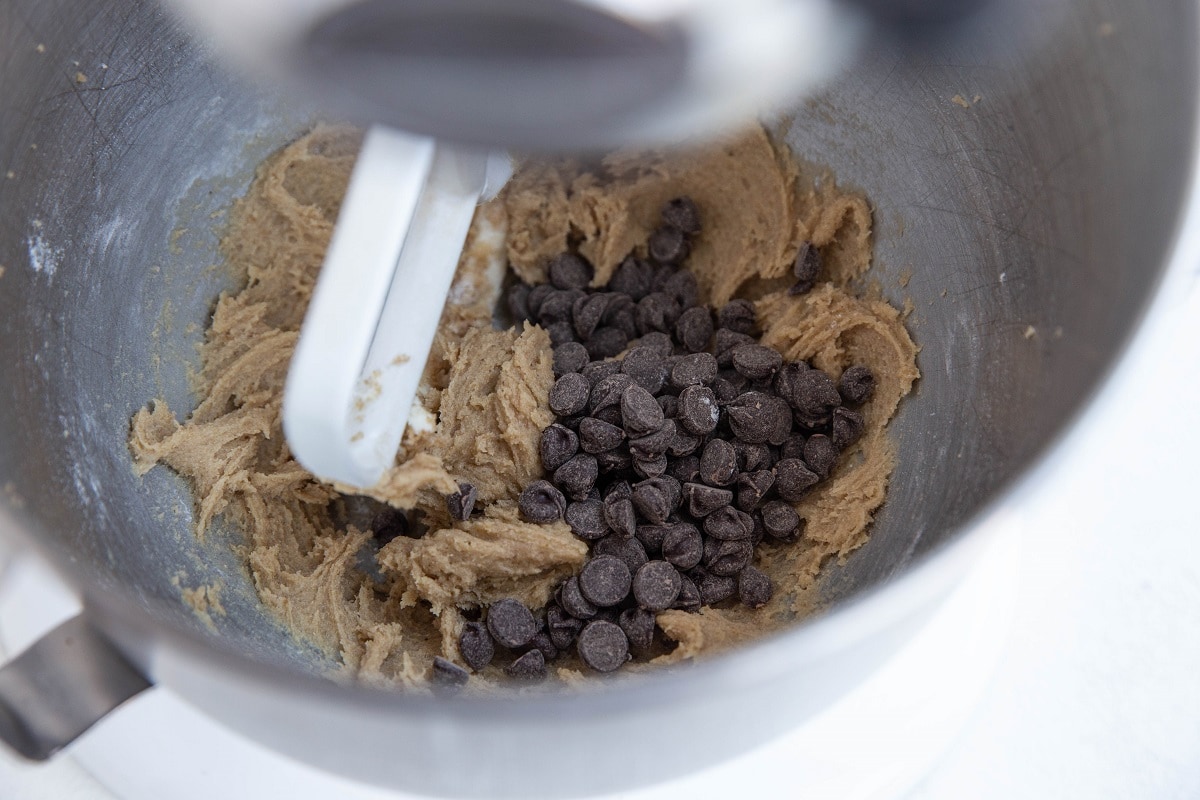 Strand mixer with gluten free cookie dough and chocolate chips on top, ready to be mixed in.